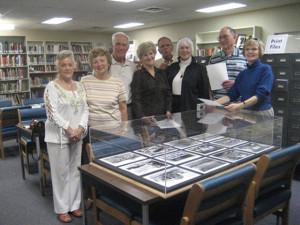 small group of former internees gather around display of Crystal City Internment Camp in University of Texas, San Antonio