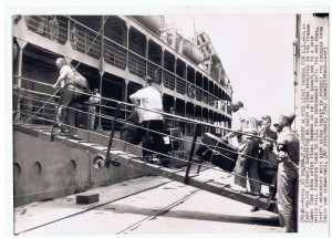 April 1942, enemy aliens in Panama board ship, with luggage, headed to internment in U.S. Guards look on.