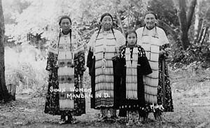 photo of 3 Native American women and a girl, dressed in ceremonial clothing
