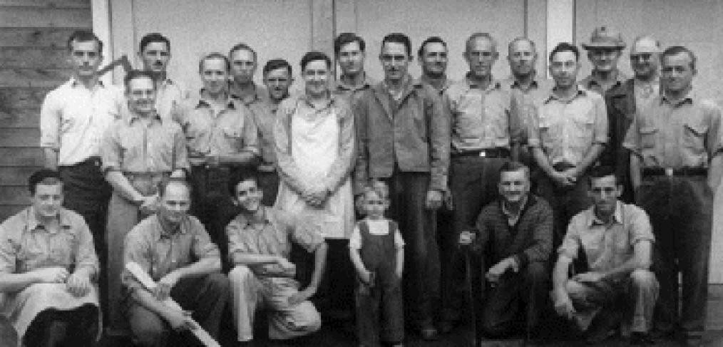 men line up for photo with small child in front, center