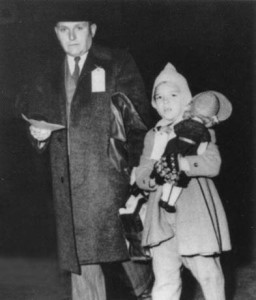 small, well-bundled child with doll, and father, with tickets