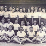 group of girls dressed in white tops, dark shorts