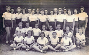 group of girls dressed in white tops, dark shorts