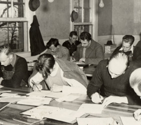 group of men at tables, studying and writing