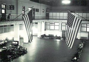 large hall with some seating areas and 2 large U.S. flags