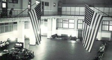 large hall with some seating areas and 2 large U.S. flags