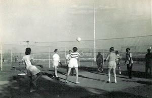 young men and women play volleyball
