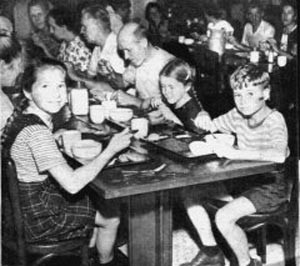 meal time; children and adults at long tables