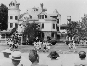 Gloucester main building, with people dancing on lawn