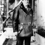 man in warm jacket and hat, with gun in holster and smoking cigarette