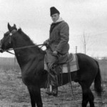 man on horseback with heavy coat and hat