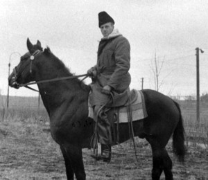 man on horseback with heavy coat and hat