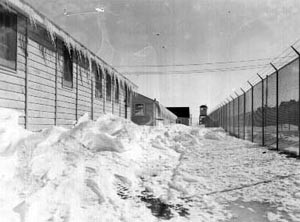 snow drifts and icicles along buildings and barbed wire fence