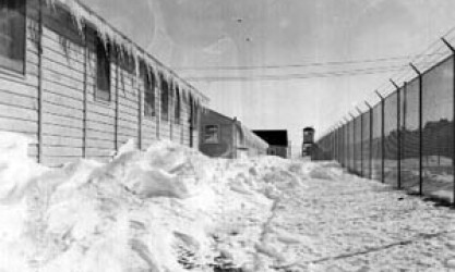 snow drifts and icicles along buildings and barbed wire fence