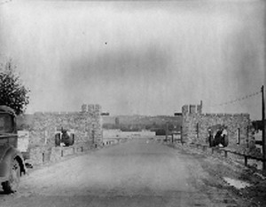 road through gated stone walls, with a cannon on each side
