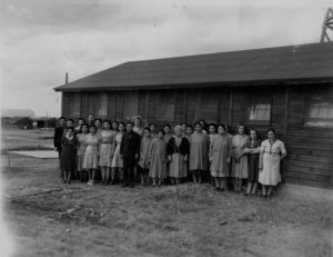 women stand in front of building